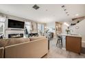 Open-concept living area with fireplace, dining space, and kitchen island seating at 13711 Ash Cir, Thornton, CO 80602