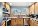 Bright kitchen featuring wood cabinets, granite countertops, stainless steel appliances, and ample storage at 8105 E Bayaud Ave, Denver, CO 80230