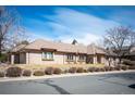 Single-story brick home featuring a three-car garage, mature landscaping, and a well-maintained front lawn at 7931 W Paine Ave, Lakewood, CO 80235