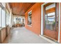 Inviting outdoor porch with brick accent wall, wood ceiling, and stylish seating area at 2096 S Logan St, Denver, CO 80210