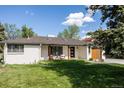 Attractive single-story home with a well-maintained lawn and a modern front door at 3540 Everett St, Wheat Ridge, CO 80033