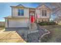 Charming two-story home features a bright red front door and attached two-car garage at 11278 W 103Rd Dr, Broomfield, CO 80021