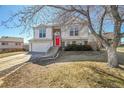 Charming two-story home features a bright red front door and attached two-car garage at 11278 W 103Rd Dr, Broomfield, CO 80021