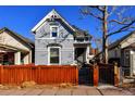 Quaint gray home with bright white trim, wood fence, and a secure front gate, creating a welcoming entrance at 1322 N Kalamath St, Denver, CO 80204