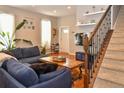 Bright living room with hardwood floors, a cozy sofa, and a staircase featuring dark iron railings at 1322 N Kalamath St, Denver, CO 80204