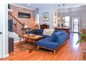 Inviting living room featuring exposed brick, hardwood floors, and a comfortable blue sectional sofa at 1322 N Kalamath St, Denver, CO 80204