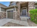 Inviting front porch with stone accents, double doors and cozy seating area with rocking chairs at 5010 Persimmon Ln, Castle Rock, CO 80109