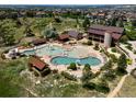 Aerial view of community pool complex with pools, lounge chairs, and recreational facilities in a residential area at 11945 S Saunter Ln, Parker, CO 80138