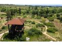 Scenic observation tower with a brown roof overlooking a green meadow landscape with walking trails at 11945 S Saunter Ln, Parker, CO 80138