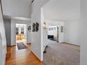 Open-concept living area with hardwood floors flowing into a carpeted living room at 8441 Urban Ct, Arvada, CO 80005