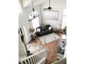 Comfortable living room with hardwood floors, high ceilings, fan, and natural light from large windows at 8769 S Dudley St, Littleton, CO 80128