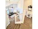 View from the staircase of the living room with hardwood floors, a ceiling fan, and natural light at 8769 S Dudley St, Littleton, CO 80128