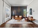 A modern living room featuring hardwood floors, stylish decor, and a dark accent wall at 3043 W 109Th Pl, Westminster, CO 80031