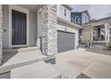 A close up of the front exterior showing stone accents, a covered entry, and a dark front door at 4903 Basalt Ridge Cir, Castle Rock, CO 80108