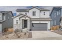 Two-story home featuring gray siding, stone accents, a two-car garage, and solar panels on the roof at 4903 Basalt Ridge Cir, Castle Rock, CO 80108