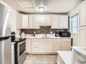 Modern kitchen with stainless steel appliances, white cabinetry, and mosaic backsplash at 3304 W 3Rd Ave, Denver, CO 80219