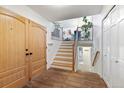 Bright entryway featuring wood floors, stairway, and coat closet at 12466 E Amherst Cir, Aurora, CO 80014