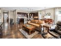 A stunning living room seamlessly flows into the kitchen, featuring elegant hardwood floors and abundant natural light at 6592 Club Villa Rd, Parker, CO 80134