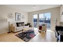 Bright living room with hardwood floors, modern decor, and a sliding door to a balcony at 1438 Little Raven St # 306, Denver, CO 80202