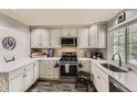 Well-lit kitchen with white cabinets, stainless steel appliances, and mosaic backsplash at 10987 Cannonade Dr, Parker, CO 80138