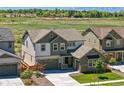 Aerial view showcasing a two-story home, nearby construction, a lush field, and mountain views at 740 Meadowlark Dr, Erie, CO 80516