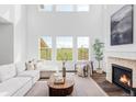 Bright living room with soaring ceilings, gas fireplace, and a large window showcasing a serene view at 740 Meadowlark Dr, Erie, CO 80516