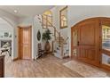 Inviting foyer featuring wood floors, staircase, arched windows and ample lighting at 24768 Foothills N Dr, Golden, CO 80401