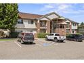 Condo exterior featuring brick accents, siding, multiple balconies, and convenient parking spaces at 875 E 78Th Ave # 9-2, Denver, CO 80229