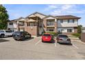 Condo exterior featuring brick accents, siding, multiple balconies, and convenient parking spaces at 875 E 78Th Ave # 9-2, Denver, CO 80229