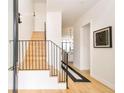 Bright foyer with hardwood floors, modern black metal stair railing, and beautiful artwork at 1921 W 37Th Ave, Denver, CO 80211