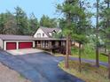 Charming home with a covered porch, attached garage and a long driveway at 4305 Red Rock Dr, Larkspur, CO 80118