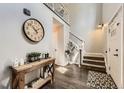 Spacious foyer with hardwood floors, a staircase, and decorative console table at 4305 Red Rock Dr, Larkspur, CO 80118