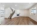 Spacious living room with hardwood floors, fireplace, and staircase at 676 Apex Rise St, Erie, CO 80516