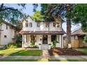 Traditional two-story home with a manicured lawn, mature trees and inviting entrance at 1815 S Ogden St, Denver, CO 80210