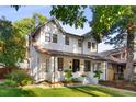 Charming two-story home featuring a well-manicured lawn and inviting front porch at 1815 S Ogden St, Denver, CO 80210