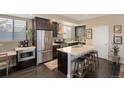 Modern kitchen features an island, stainless steel appliances, and dark cabinetry at 2044 N High St, Denver, CO 80205