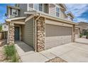 Close up of charming two-story townhome with a two-car garage and stone accents at 5957 Turnstone Pl, Castle Rock, CO 80104