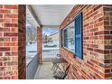 Inviting brick porch with a cozy seating area, ideal for enjoying the outdoors and neighborhood views at 18755 Burlington Pl, Denver, CO 80249