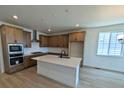Bright kitchen features an island with quartz countertops, stainless steel appliances, and wood cabinets at 8326 Cokedale Cir, Littleton, CO 80125