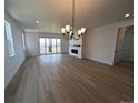 Spacious living room boasting a modern chandelier, fireplace, and sliding glass doors to a balcony at 8326 Cokedale Cir, Littleton, CO 80125