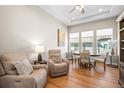 Cozy living room with wood floors, a ceiling fan, and comfortable seating next to large windows at 8784 S Riviera Ct, Aurora, CO 80016