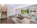 Staged living room with hardwood floors, large windows, and neutral decor at 3806 S Yosemite St, Denver, CO 80237