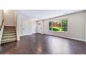 Bright living room boasts hardwood floors, a staircase, and a large window overlooking the yard at 3806 S Yosemite St, Denver, CO 80237