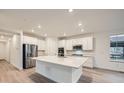 Bright, modern kitchen with stainless steel appliances, a large island, and white cabinetry at 595 Twilight St, Erie, CO 80516