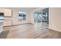 Bright living space with a sliding glass door to the deck, white cabinets and light wood floors at 595 Twilight St, Erie, CO 80516