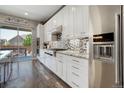 Modern kitchen featuring stainless steel appliances, white cabinetry, and sliding glass door to the deck at 15804 Elizabeth E Cir, Thornton, CO 80602