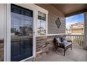 Inviting front porch with stone accents, a comfortable chair, and a view of the neighborhood at 4307 Beautiful Cir, Castle Rock, CO 80109