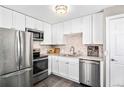 Modern kitchen with stainless steel appliances, white cabinets, and granite countertops at 1391 Elmira St, Aurora, CO 80010