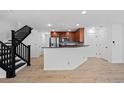 Spacious and bright living area featuring an open staircase and view of the kitchen at 11935 Riverstone Cir # 6D, Henderson, CO 80640