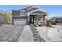 Two-story home with gray siding, brick accents, and a snowy front yard at 3272 Brushwood Dr, Castle Rock, CO 80109